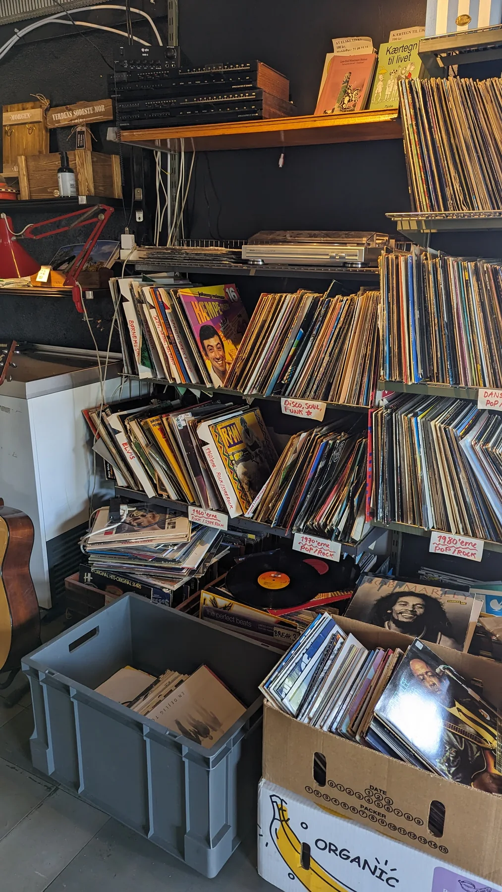 Vinylplader på hylder og i kasser ved en pladespiller